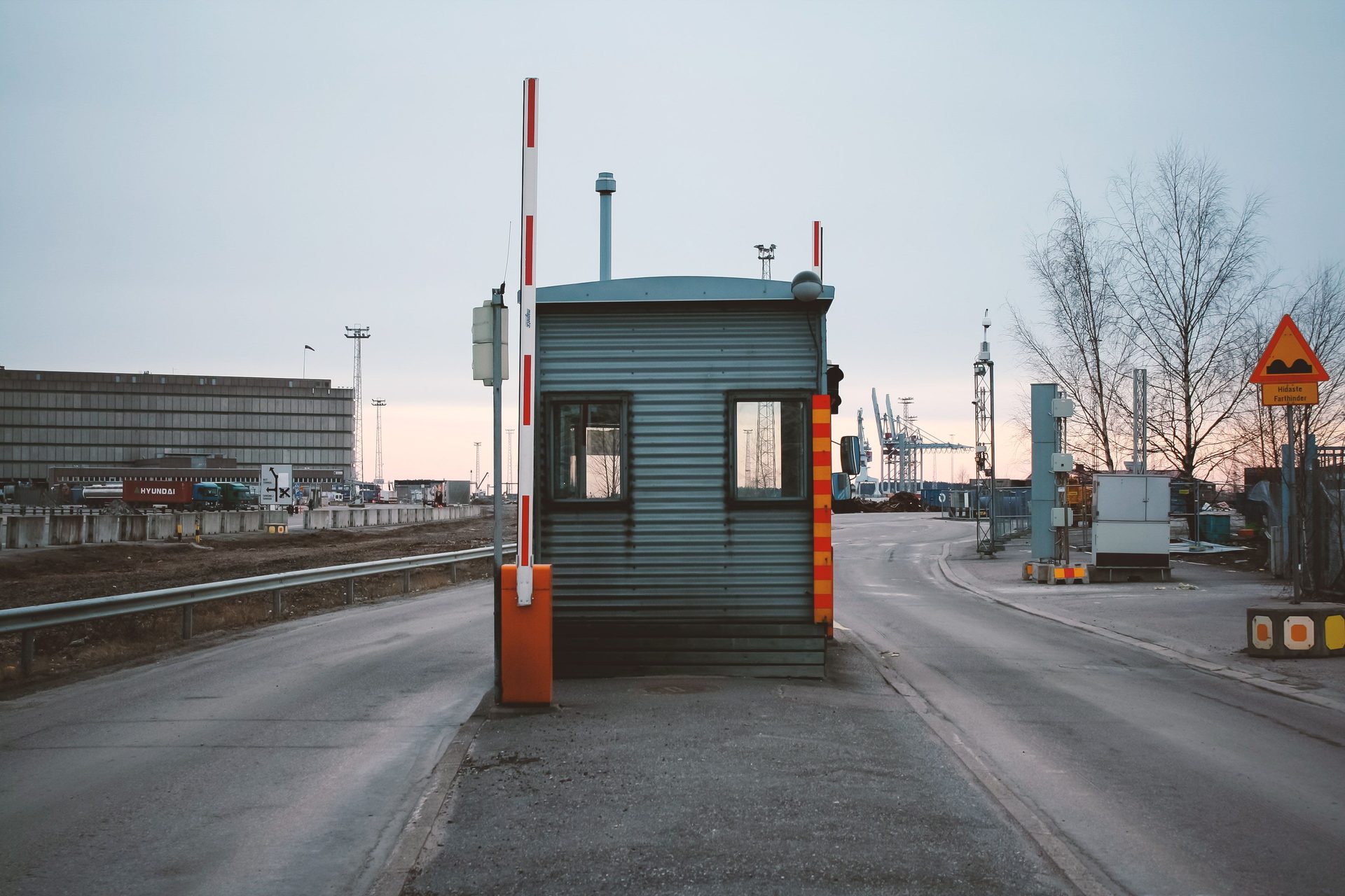 A checkpoint booth with a raised barrier at a port entrance in Helsinki
