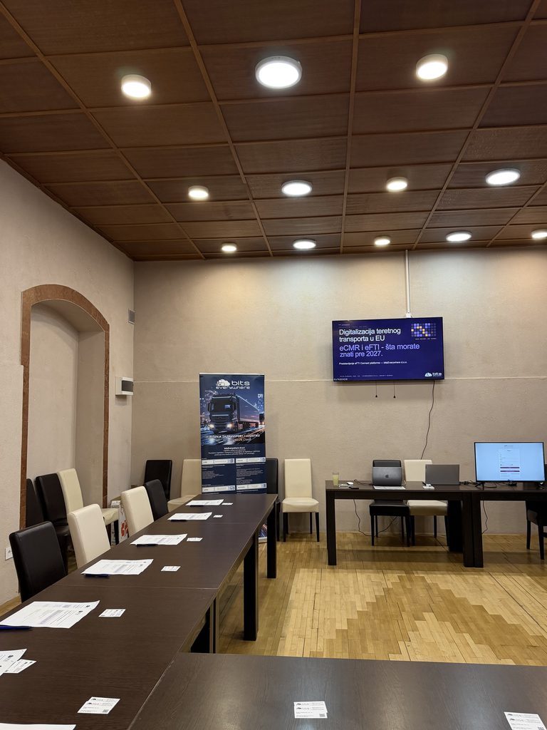 The room in Senta before the guests arrived: the title slide on the screen, the roll-up, and the questionnaires laid out along the table